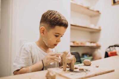 Child playing with clay in an after-school club in Dubai