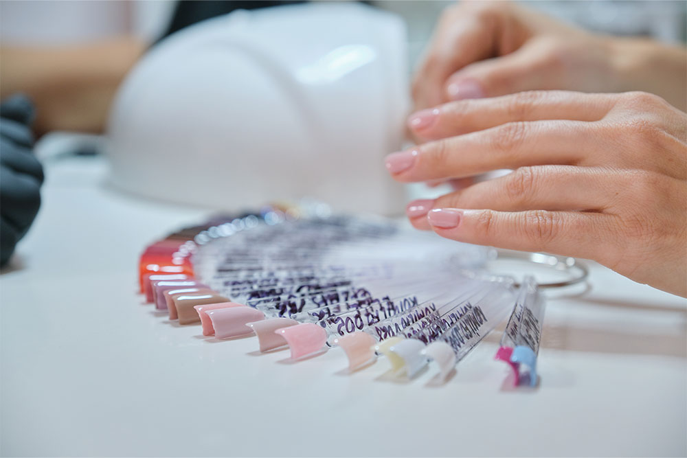 A girl getting nail extensions at a nail salon