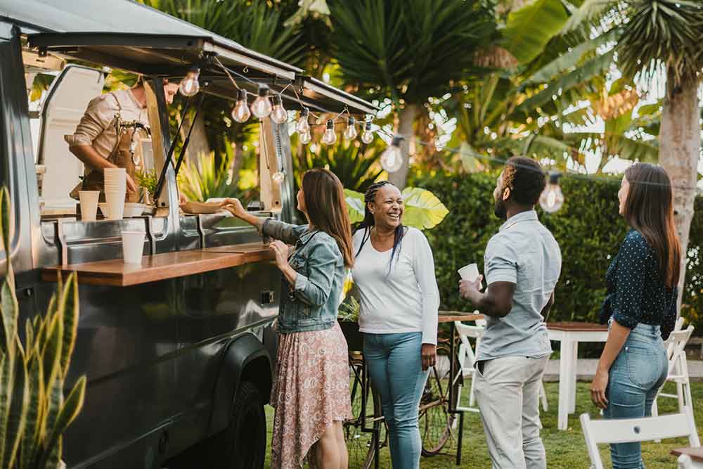 friends talking near the food truck in the park 