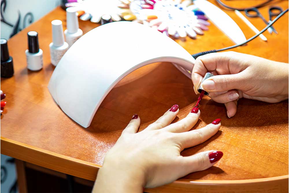  A female having red gel polish at a nail polish