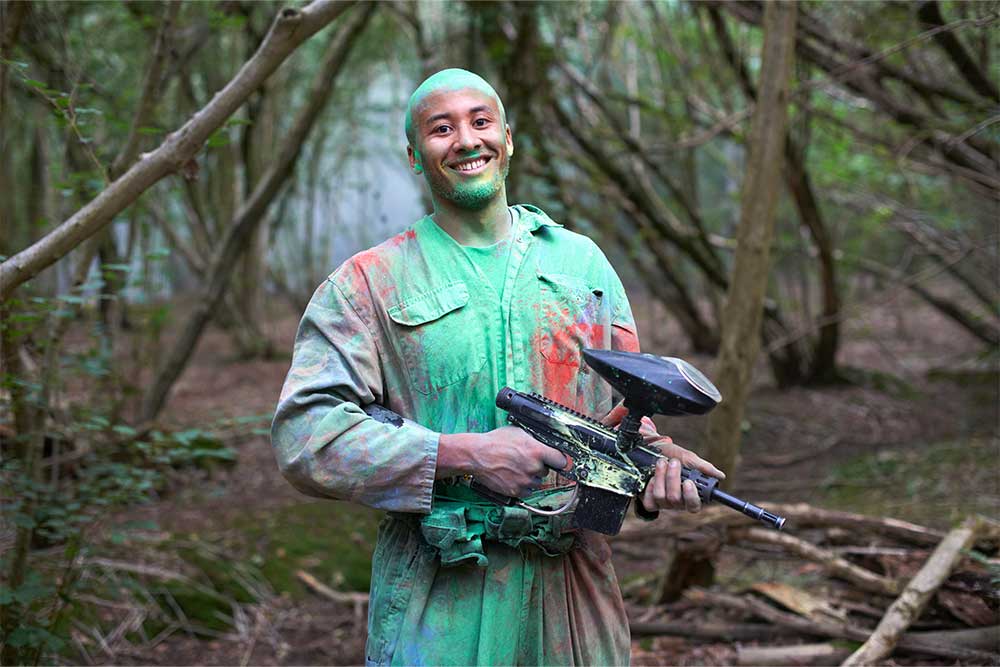 Paintball player covered in paint spots 