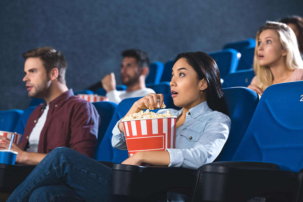 Woman eating popcorn while watching a movie
