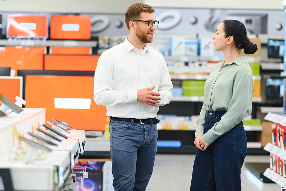 A salesman giving advice to a female customer