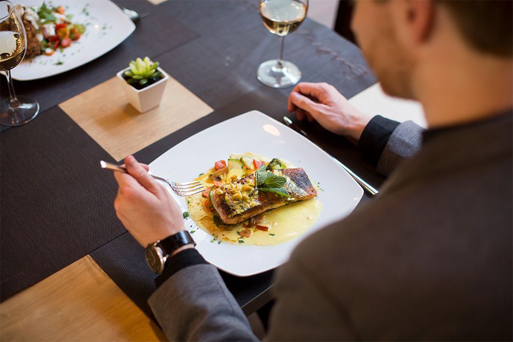 A man having grilled salmon at a fine dining restaurant in Abu Dhabi