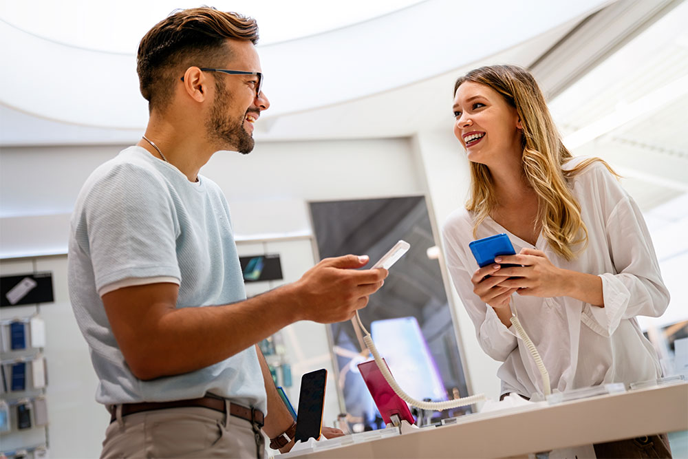 Staff guiding a customer over features of a mobile phone