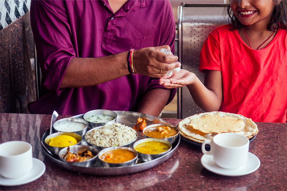 Father and a little girl having Indian food at the restaurants in karama