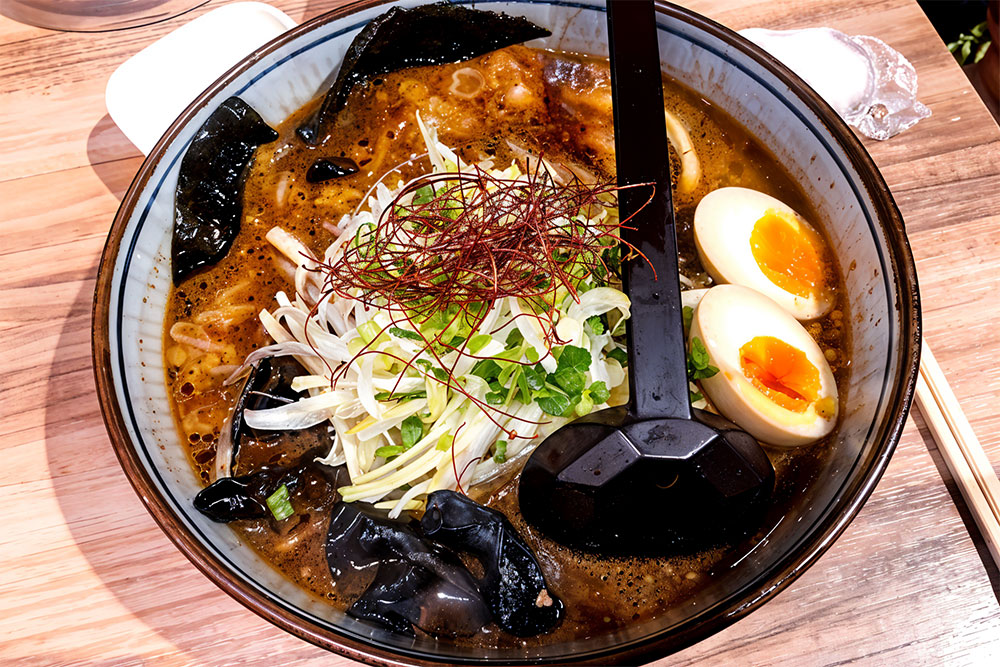 A bowl of ramen with eggs and other toppings