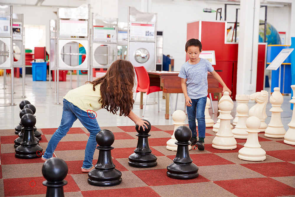 School children playing chess on a large board