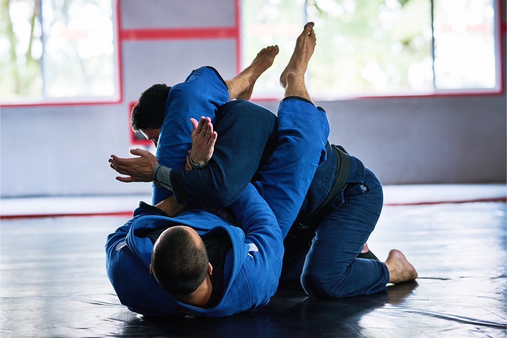 athletes sparring on the floor of their dojo.