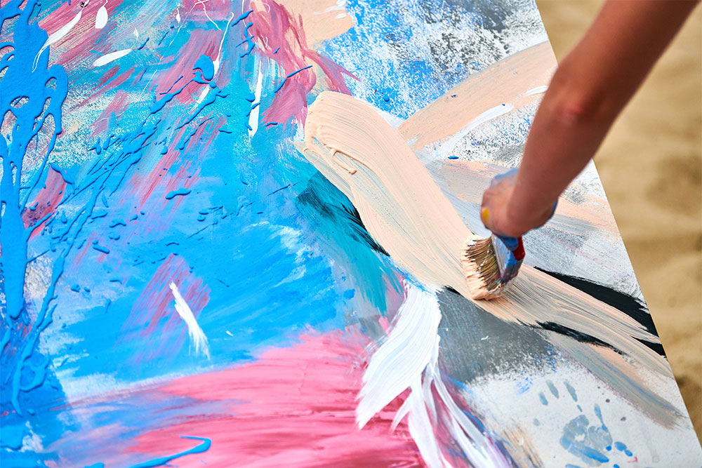 Expressing creativity by painting with pinks and blues on a canvas