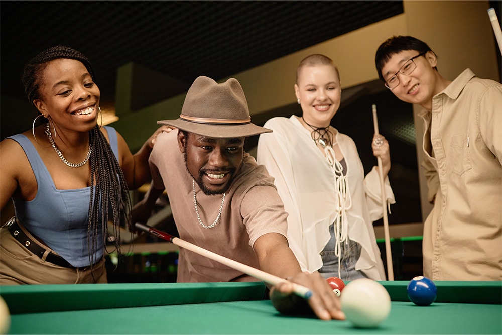 A group of friends playing billiards