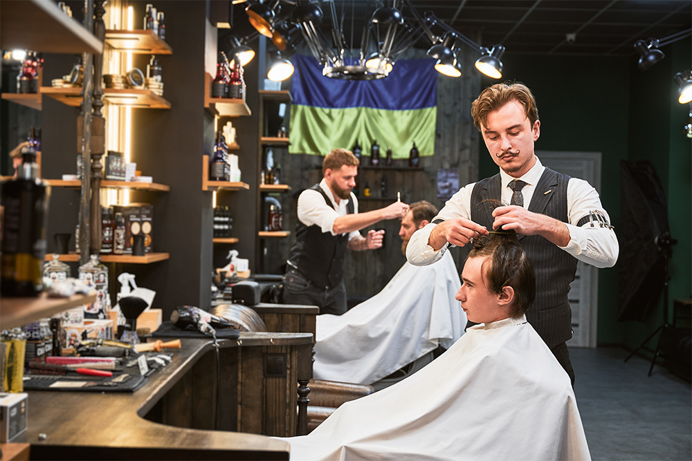 professional barbers working on a customer’s hair