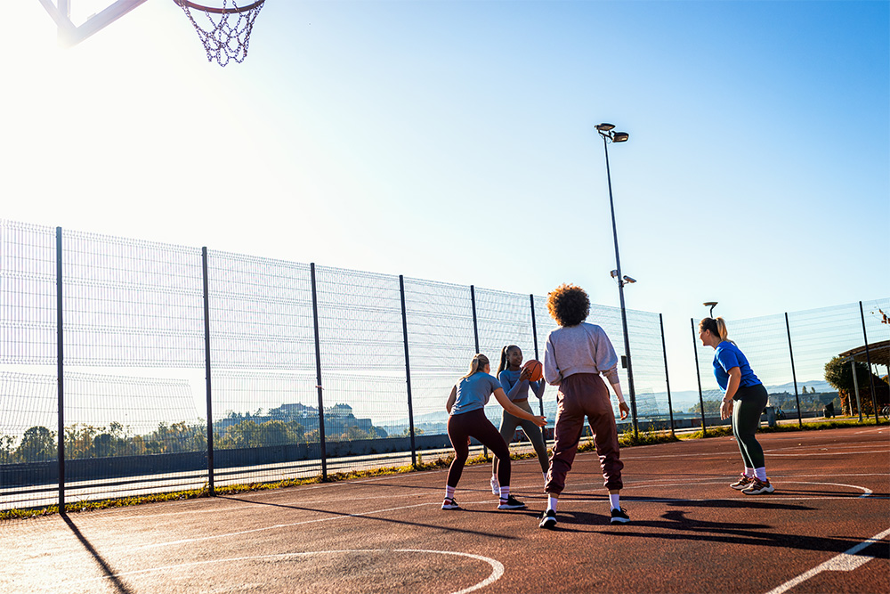 Group of friends playing basketball at one of the courts