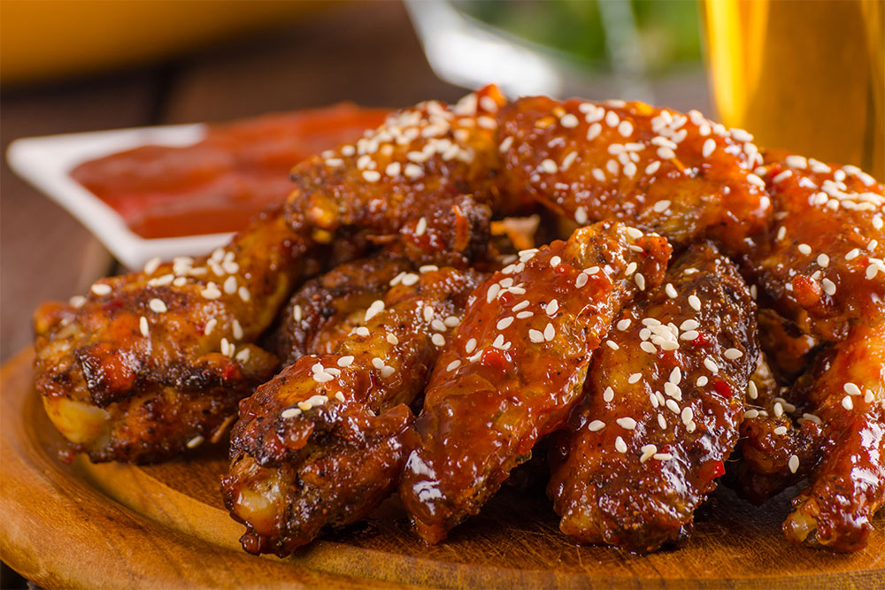 Spicy grilled chicken wings served with hot sauce at the best Korean restaurant in Sharjah