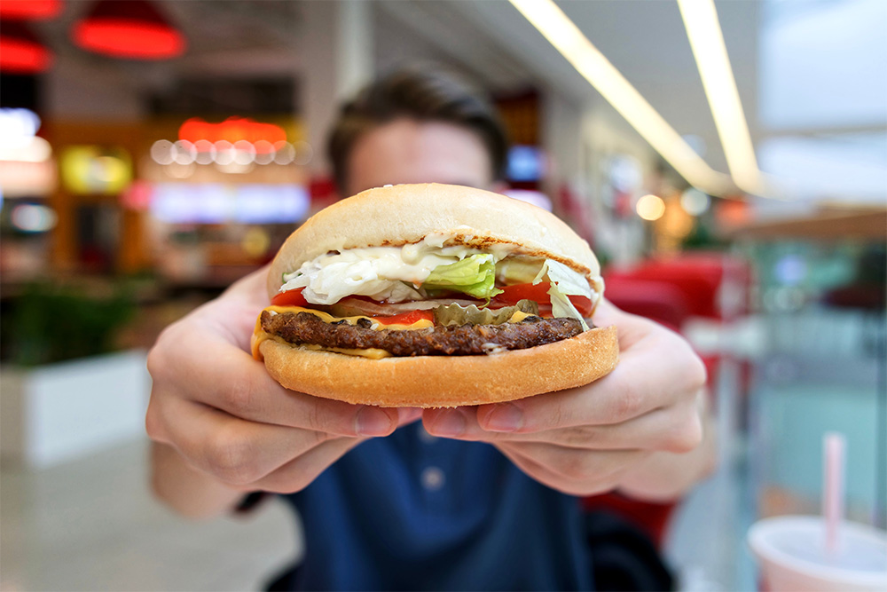 man showing burger in Abu Dhabi