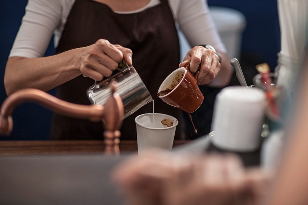 Barista preparing iced coffee in a coffee shop in Sharjah