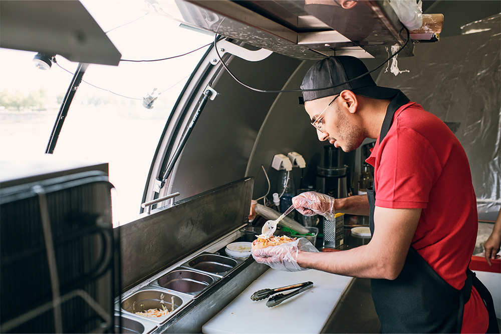 cook making a burger at Food Truck