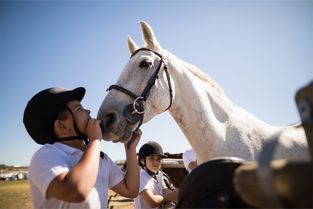 Kids learning to ride a horse