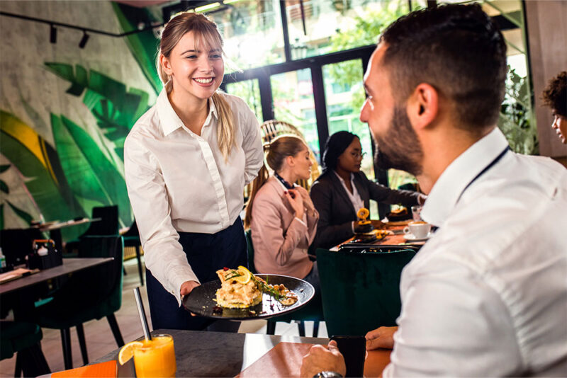 A waitress serving sandwich at a Brazilian Restaurant Abu Dhabi