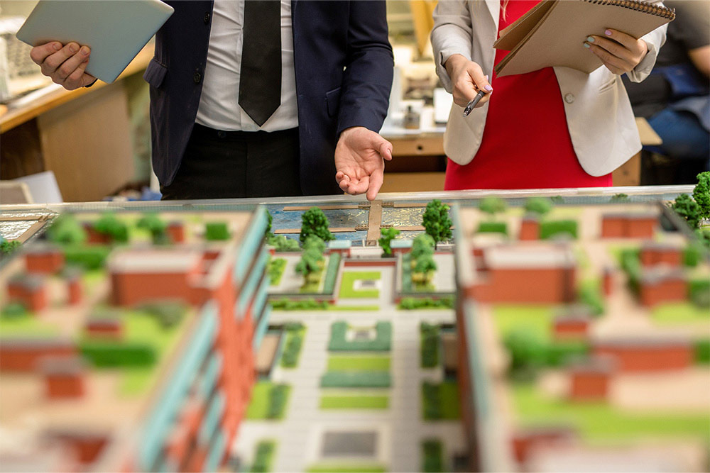 architect pointing at part of city layout during presentation