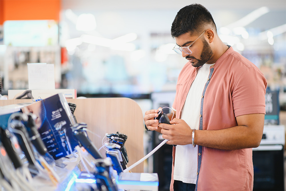 A man purchasing a trimmer in an electronic store