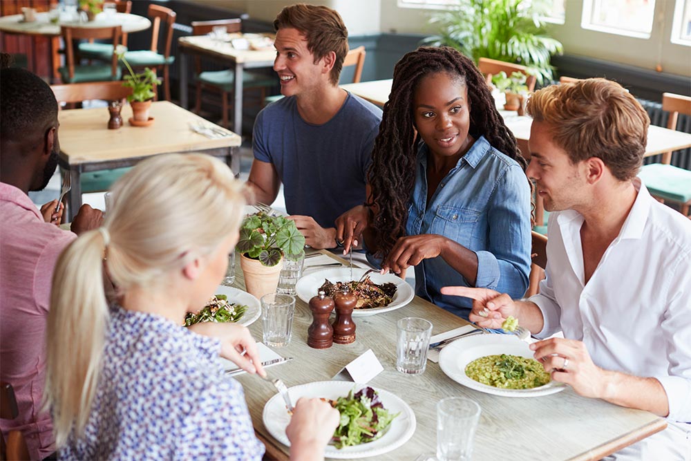 Multiracial friends at a vegetarian restaurant