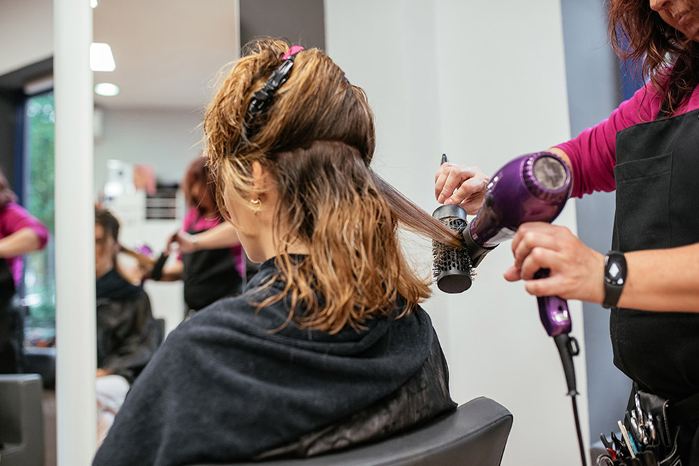 Hairdresser styling the hair of a customer