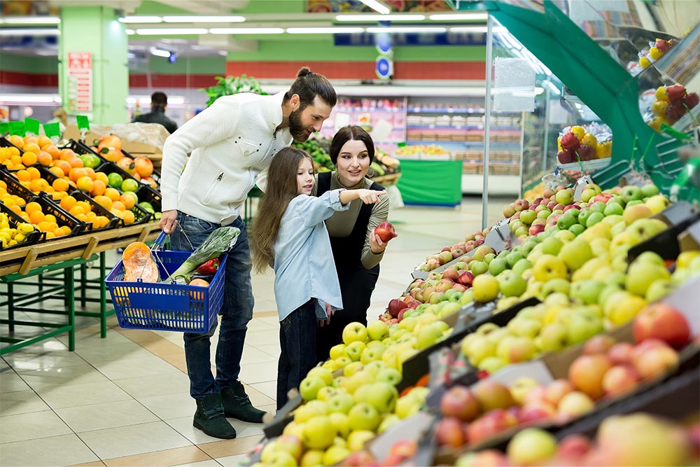 A family buying fruits at a supermarket