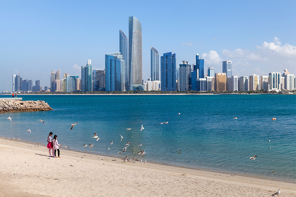 Abu Dhabi cityscape with a beach in front.