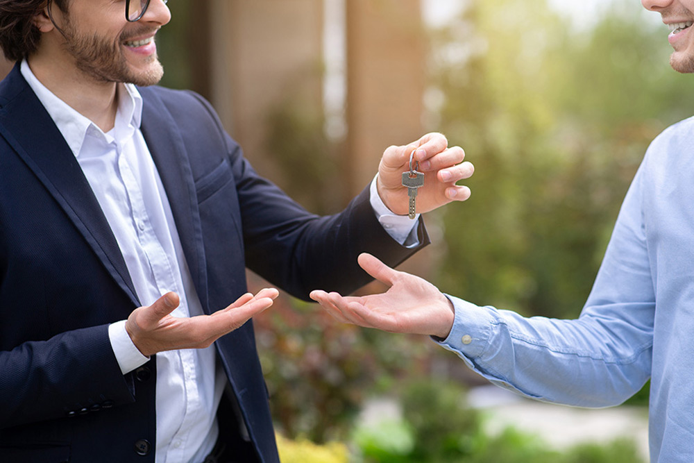 Estate agent handing over house keys 