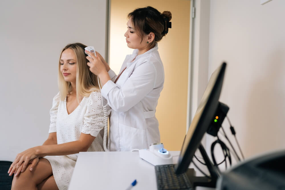 Dermatologist doing hair treatment to a patient