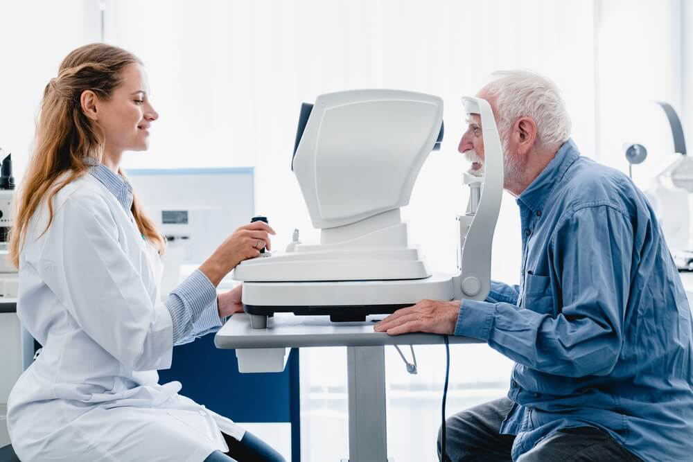 A doctor doing an eye checkup of an old man