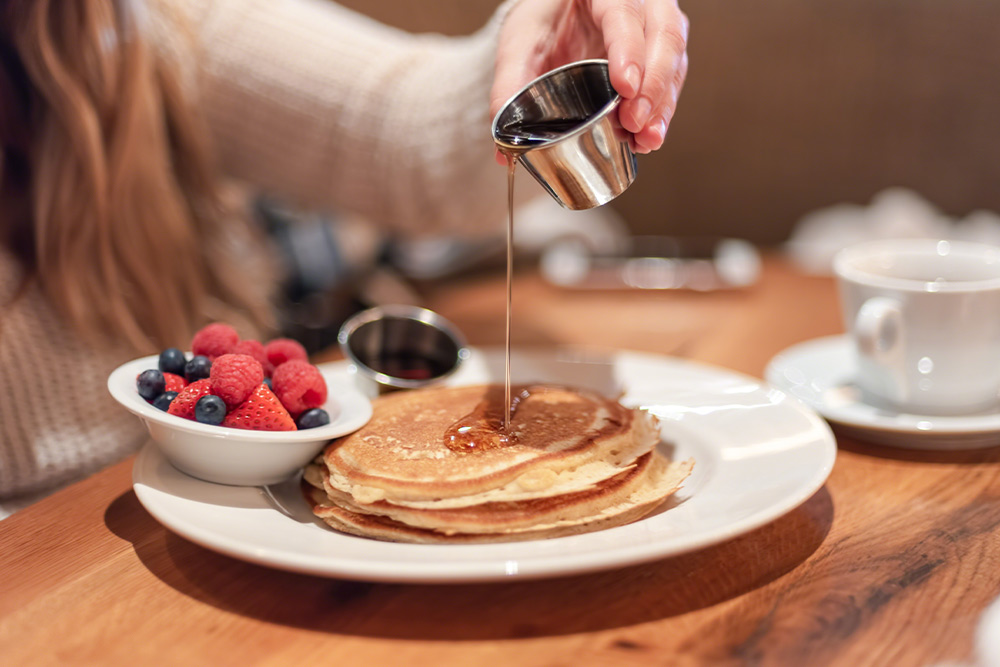 Pouring Maple Syrup on Pancakes