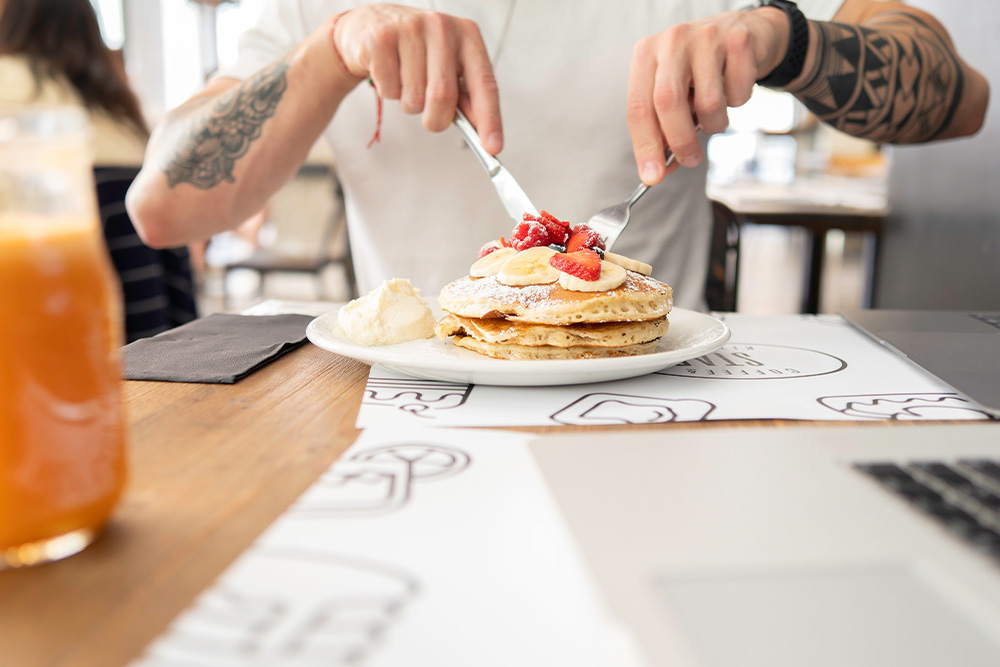 a man eating pancake at Larte Cafe bur dubai