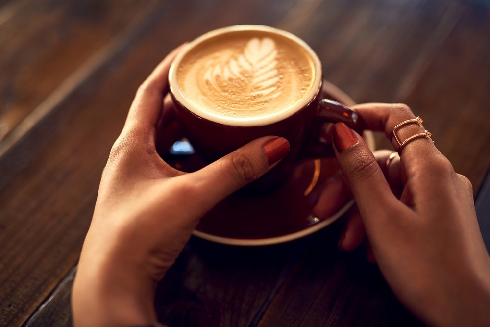 a woman holding a cup of coffee at Arabian Tea House