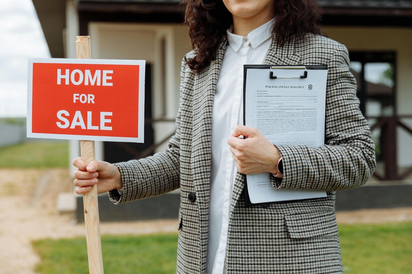 Close-up of a female Real Estate Agent Holding a Home For Sale Sign