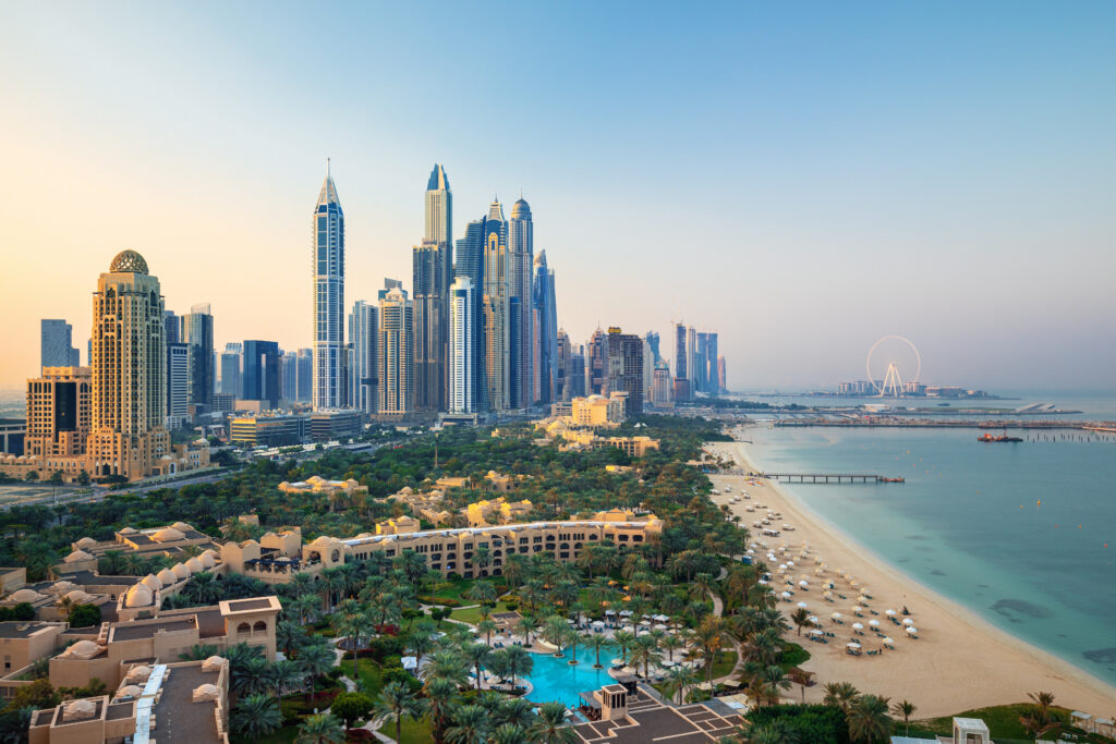 Scenic view of Dubai Marina skyline with towering skyscrapers and luxury beachfront developments, showcasing the modern urban landscape along the coastline.